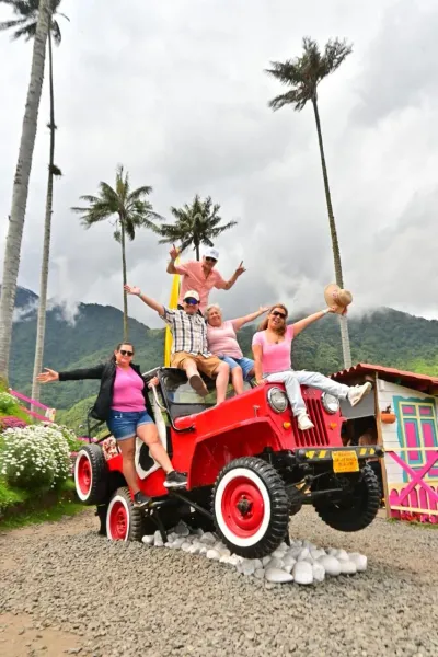 Turistas posando sobre un jeep decorativo en el mirador de la Mano de Acaime, Valle de Cocora