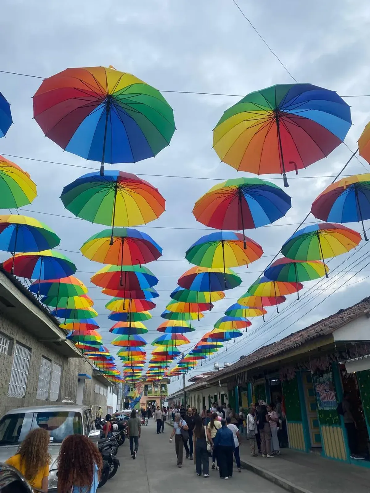 Calle de Filandia decorada con sombrillas de colores y turistas caminando